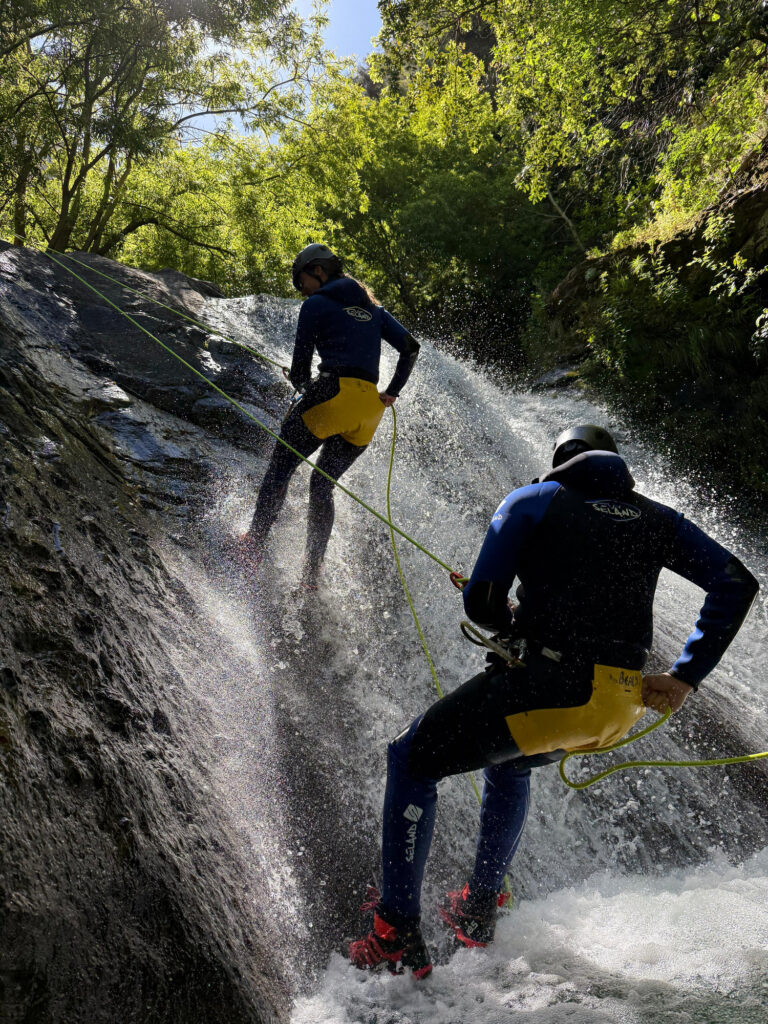 Best canyoning experiences in Madeira 2 Two canyoneers abseil down a sunlit waterfall slide in Ribeira do Cidrão, Nuns Valley, during an Intermediate Level 2 canyoning adventure with Go Explore Madeira.