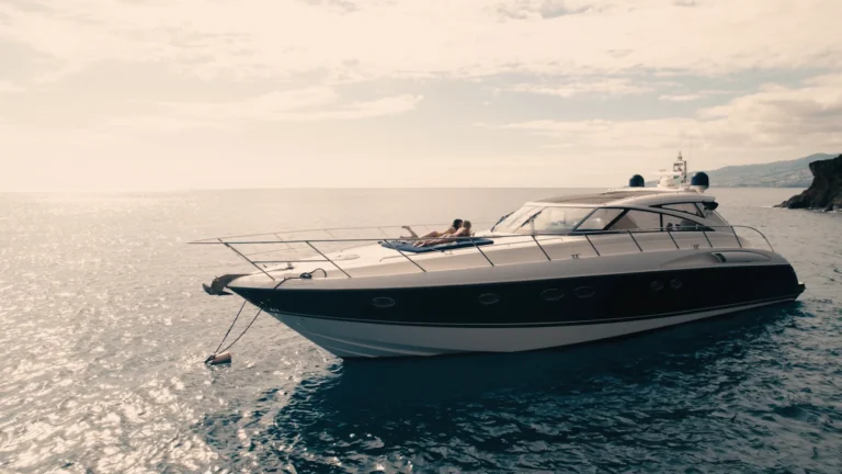 Luxury Madeira Yacht Charter Rental in the sea with two woman sunbathing, near the coast of Madeira, an experience by Luxury Charter Madeira.