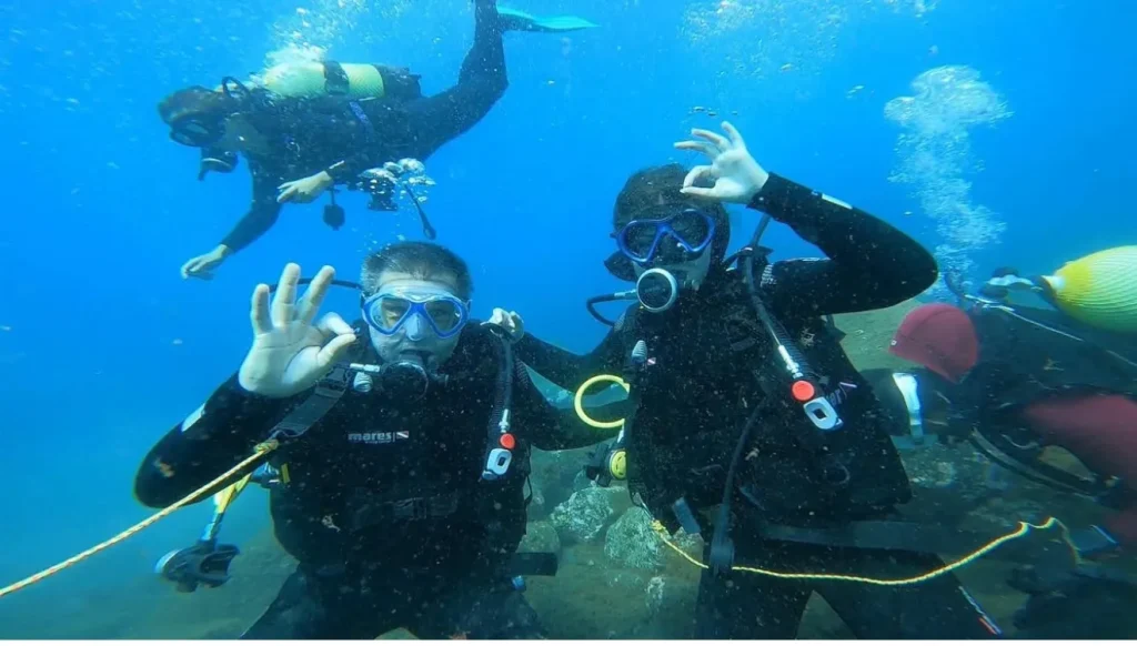 Scuba diving in Madeira, your underwater guide 4 3 scuba divers underwater showing ok signs to the camera.