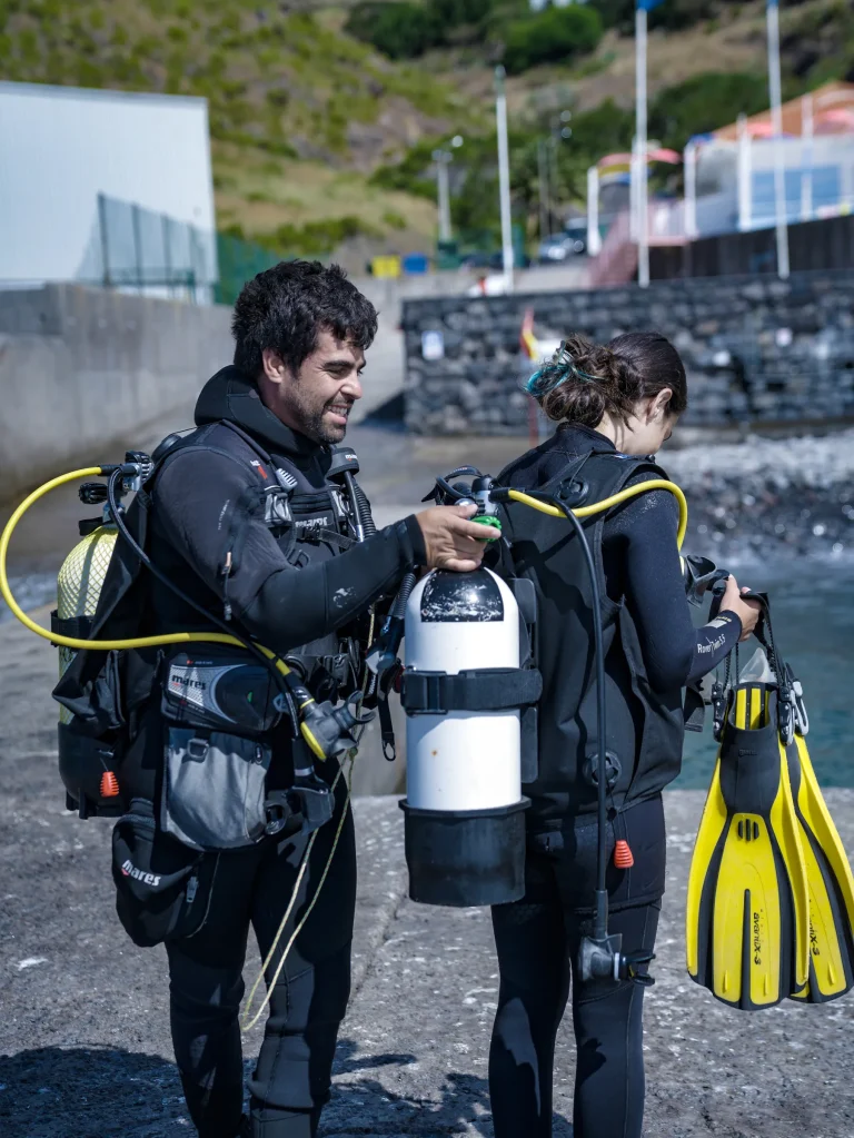 Dive instructor preparing a female diver for a Try Scuba Diving experience in Madeira, Portugal.