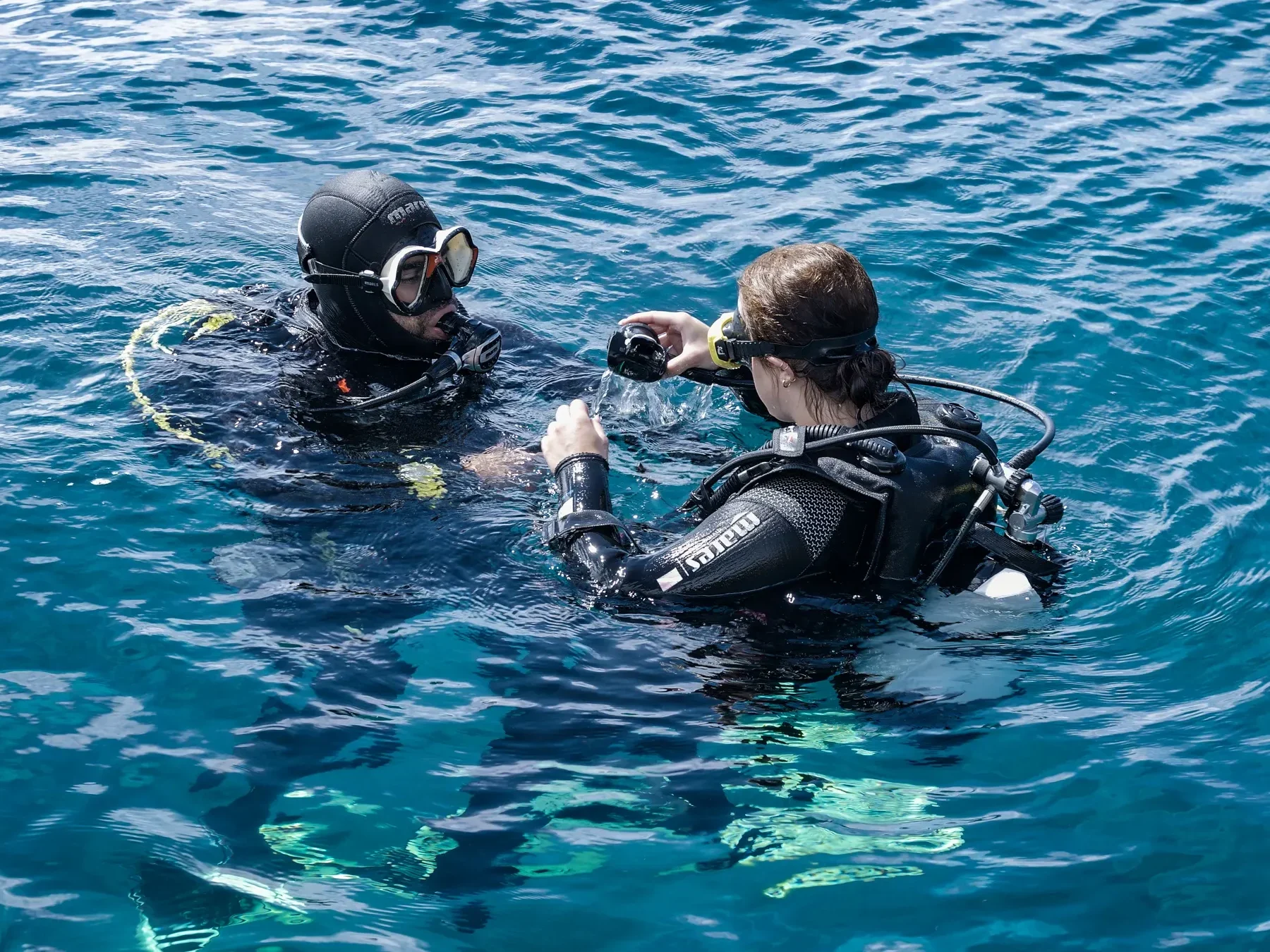 Scuba diving in Madeira, your underwater guide 3 Dive instructor guiding a beginner diver in the water during the Try Scuba Diving in Madeira experience by Scorpio Madeira.
