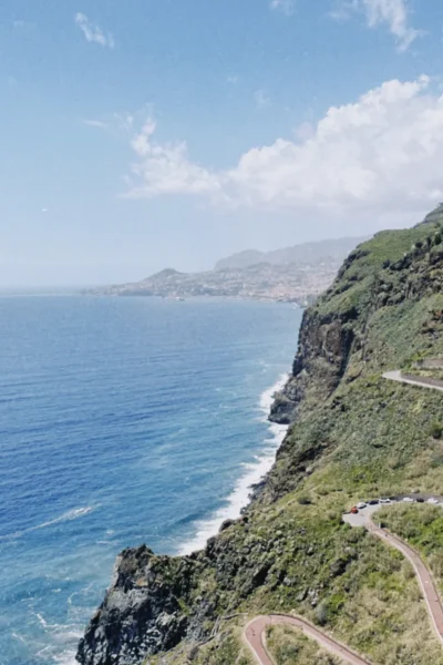 Dramatic cliffside viewpoint over the Atlantic Ocean and winding coastal road on the Self-Guided E-Bike Road Tour From Funchal to Garajau, an experience by MADcycle.