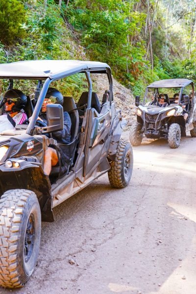 Buggy Tour Riding at Campanário with a line of off-road buggies driving along a dusty forest track, guests wearing helmets and enjoying the Madeira mountain scenery, during an experience by Buggy Funtrip Madeira.