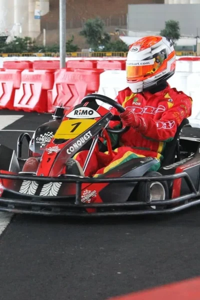 A Person with a red suit having fun and driving a Kart, under Madeira Airport, an experience by Go Kart Madeira
