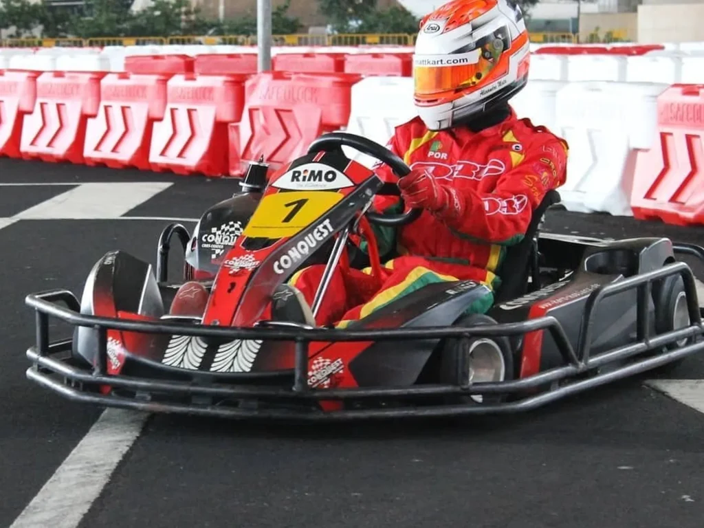 A Person with a red suit having fun and driving a Kart, under Madeira Airport, an experience by Go Kart Madeira