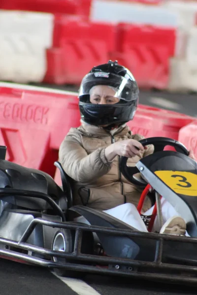 A women driving and focused on wining a karting race, under Madeira Airport, an experience by Go Kart Madeira