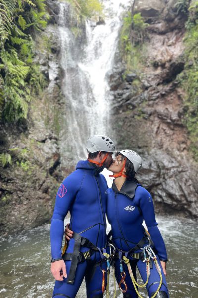 A couple of canyoneers share a kiss beside a fern-lined waterfall in Porto Novo, Camacha, during a Beginner Level 1 canyoning tour with Go Explore Madeira.