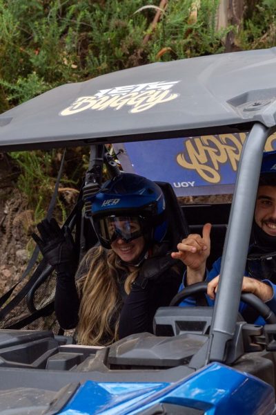 Close up of a couple inside a Buggy with green vegetation surrounding them during a Let's Buggy's half day Explorers tour experience in Madeira.