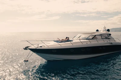 Luxury Madeira Yacht Charter Rental in the sea with two woman sunbathing, near the coast of Madeira, an experience by Luxury Charter Madeira.