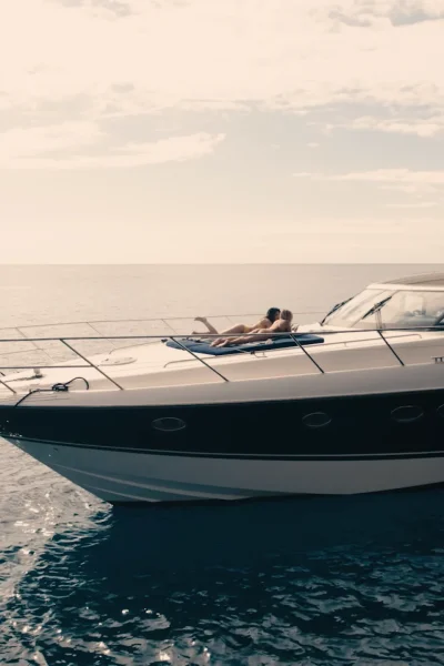 Luxury Madeira Yacht Charter Rental in the sea with two woman sunbathing, near the coast of Madeira, an experience by Luxury Charter Madeira.