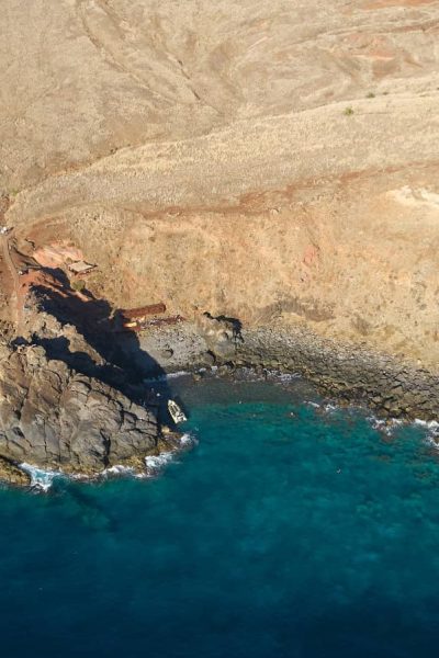 Aerial view of Ponta de São Lourenço's eroded red-and-gold volcanic cliffs meeting turquoise coves and the deep blue Atlantic , a boat tour experience by Madeira Sea Emotions.