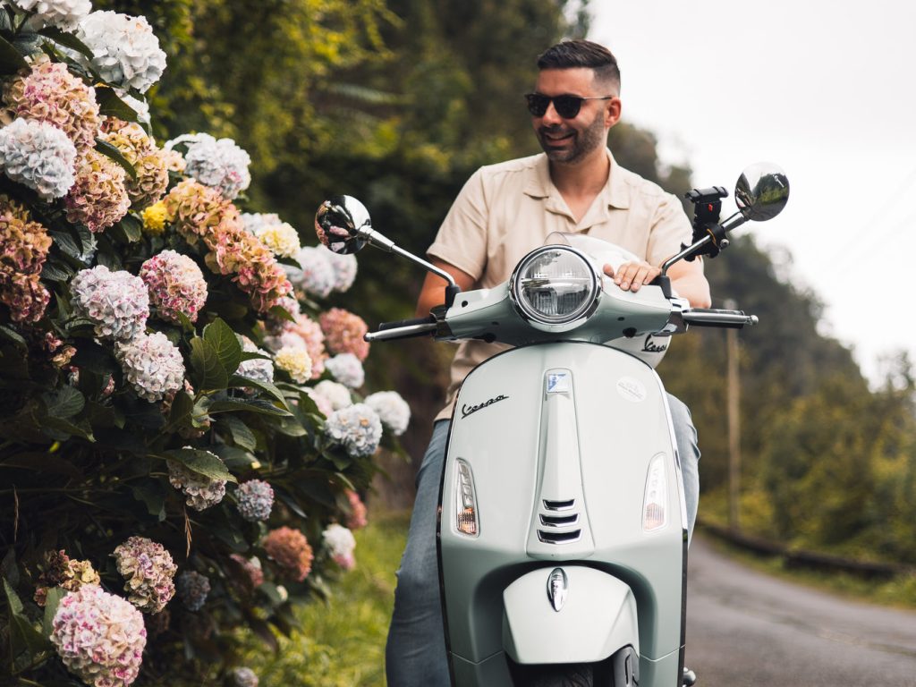 A man cruising in a vespa guided moutain tour.The type of scooter offered for rent to explore the Madeira island’s winding mountain roads and scenic viewpoints by Vespa Madeira Scooter Rent.
