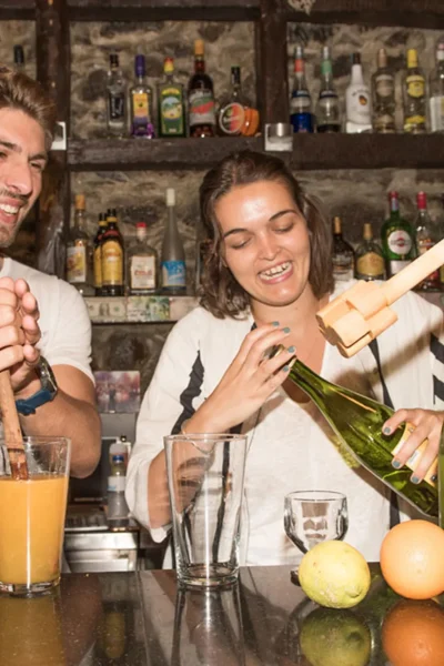 Guests learning to make traditional poncha behind the bar during the Bar hopping and Poncha Workshop, an experience by Wine Tours Madeira.