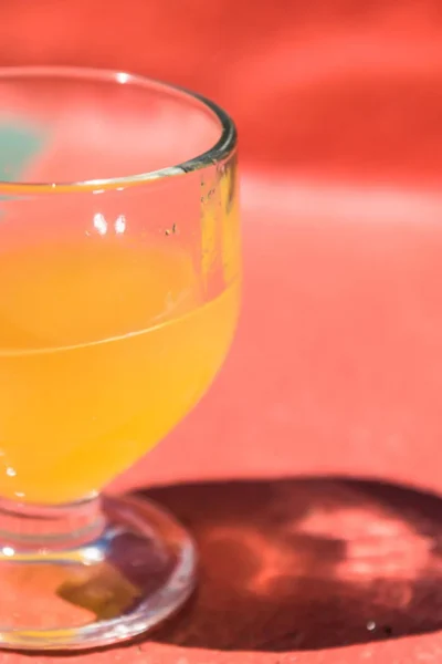 Close-up of a glass of fresh poncha on a colorful bar counter during the Bar hopping and Poncha Workshop, an experience by Wine Tours Madeira.