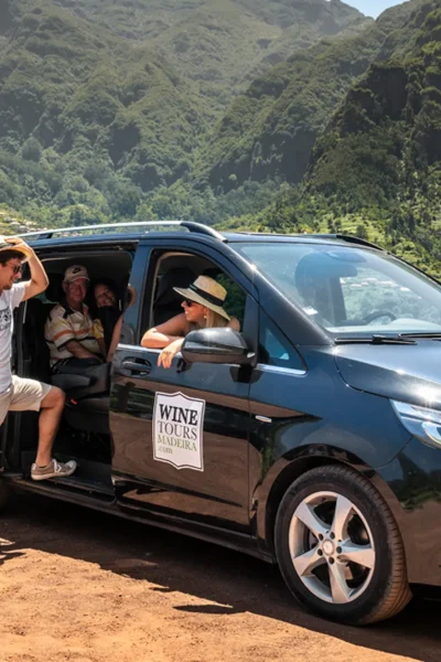 Tour group gathering at Wine Tours Madeira van amid lush Madeira mountains, an experience by Wine Tours Madeira