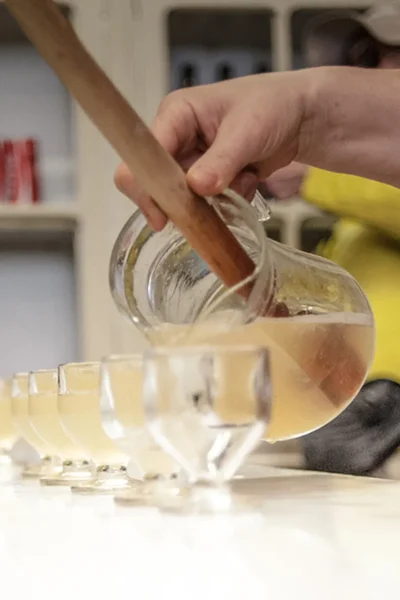 Poncha being poured from a jug into glasses with peanuts on the counter during the Wine and Food Walking Tour in Funchal, an experience by Wine Tours Madeira.