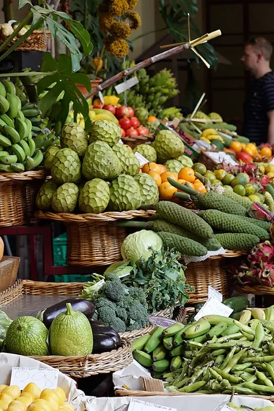 Colorful display of tropical fruits and vegetables at a Funchal farmers market during the Wine and Food Walking Tour in Funchal, an experience by Wine Tours Madeira.