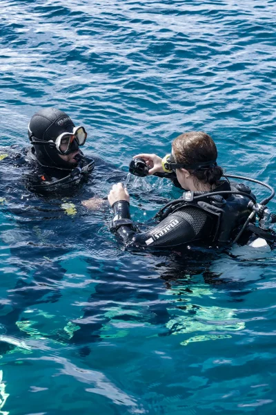 Dive instructor guiding a beginner diver in the water during the Try Scuba Diving in Madeira experience by Scorpio Madeira.